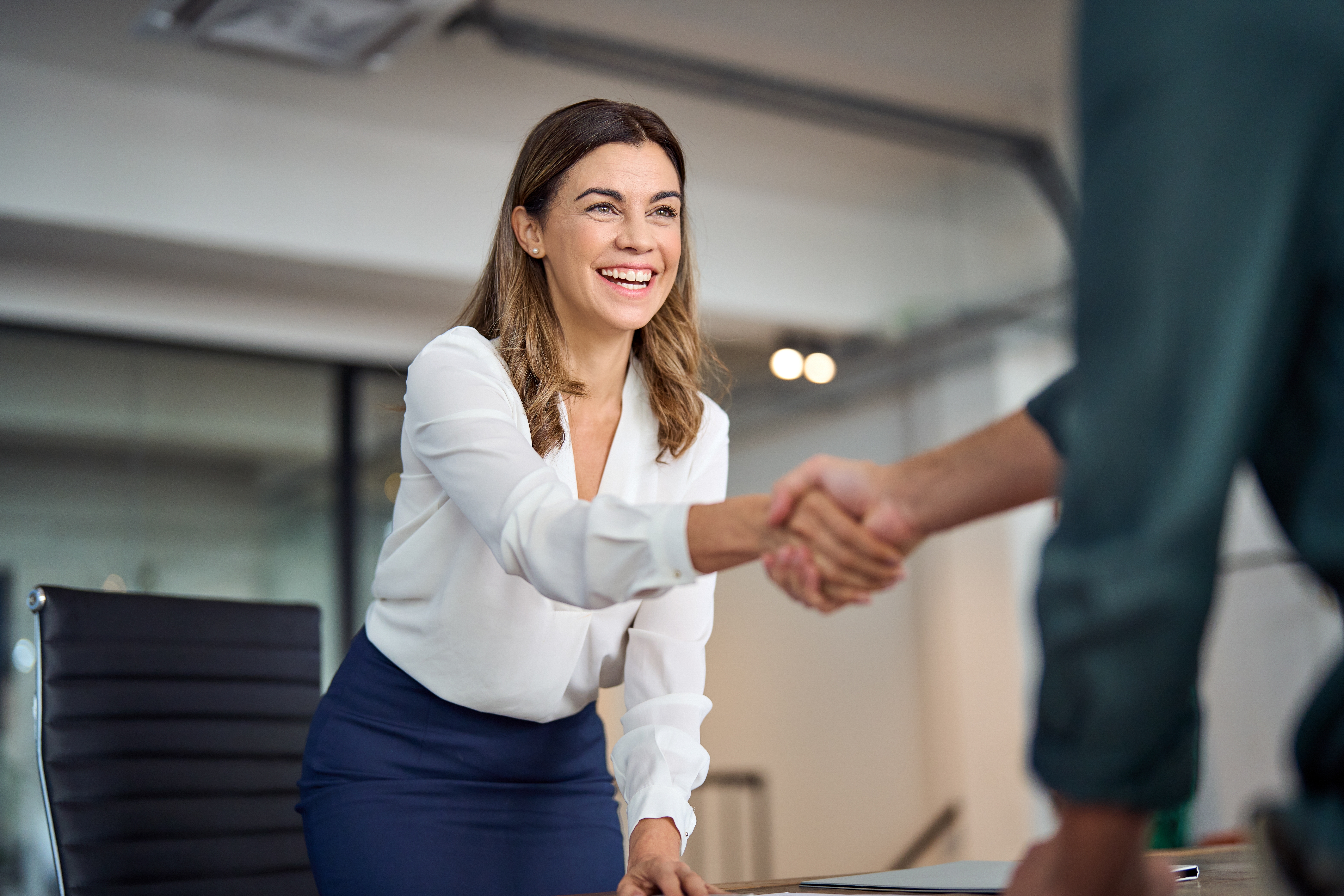 a female banking expert shaking hand with a customer